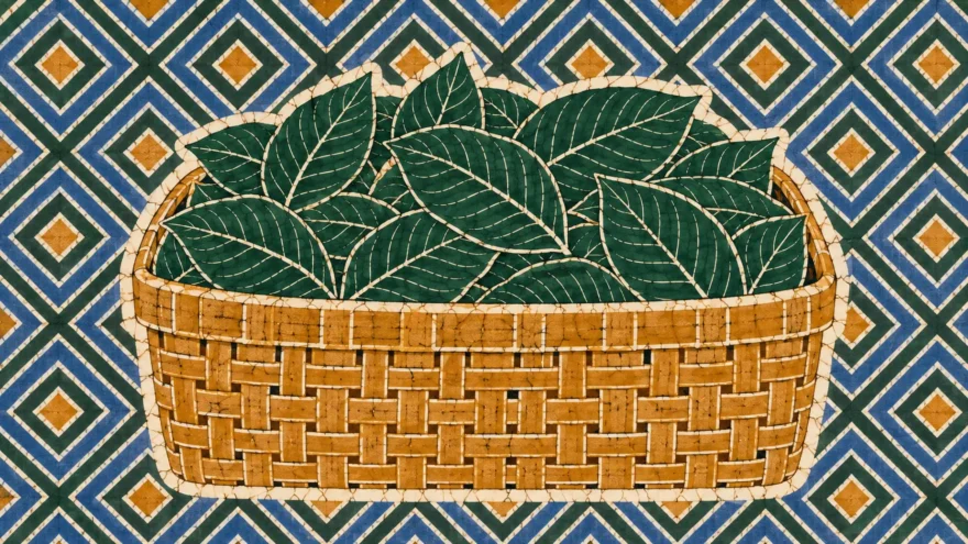A wax resist batik of a woven basket heaped with loose kratom leaves, held inside a white resist halo against a repeat of nested diamonds in blue and green.